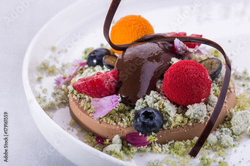 Shokolate sorbet, is served with raspberry, a sea-buckthorn and edible flowers photo