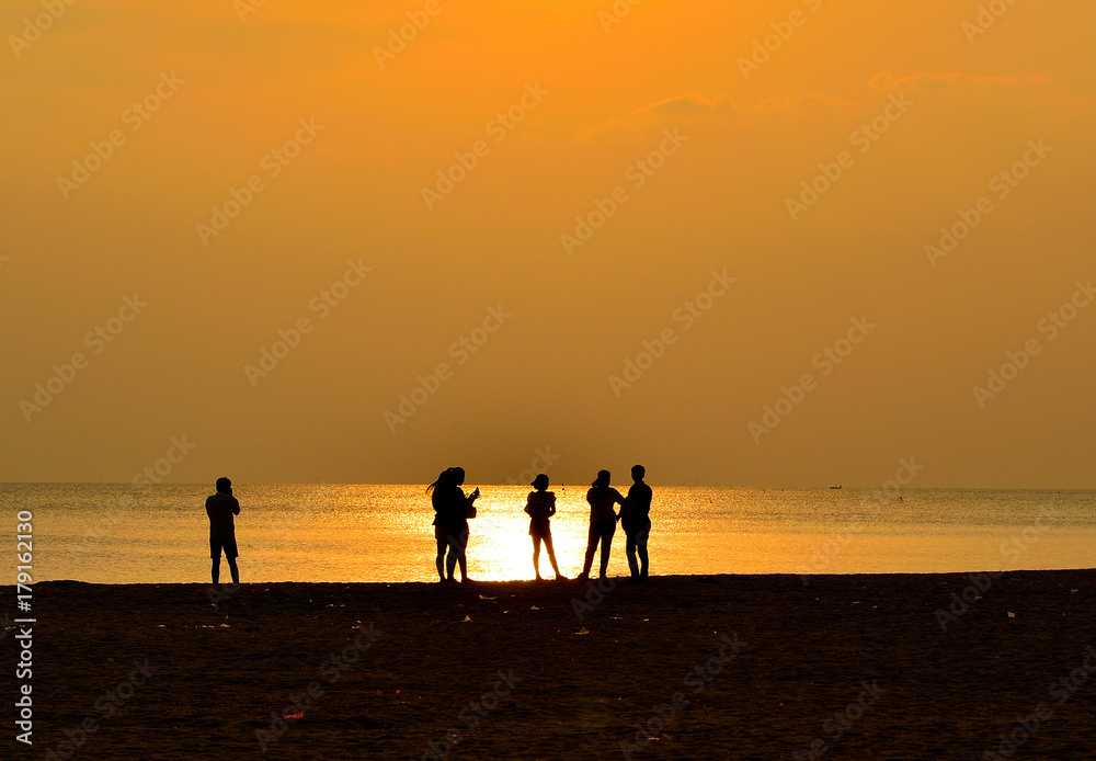 Silhouette of people on beach has sunset background Silhouette of people on beach has sunset background