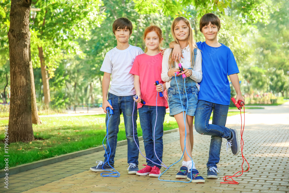 Cute little children with jumping ropes in park Cute little children with jumping ropes in park