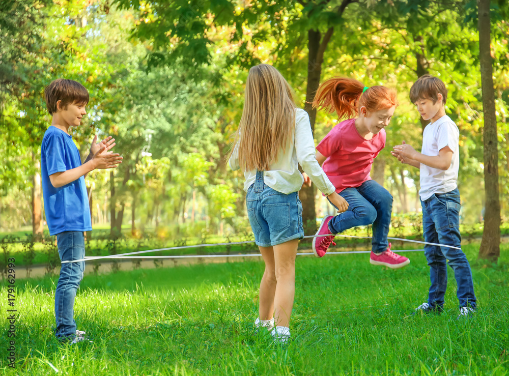 Cute little children jumping rope in park Cute little children jumping rope in park