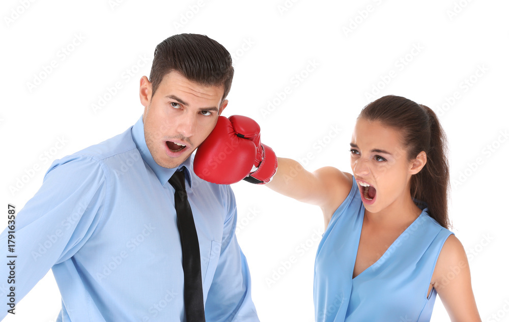 Woman in formal clothes and boxing gloves hitting businessman on white background Woman in formal clothes and boxing gloves hitting businessman on white background