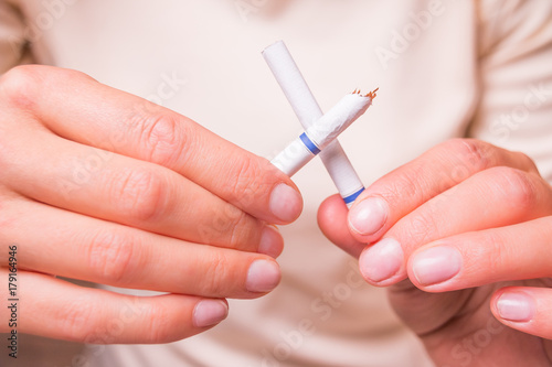 image of a crushed cigarette butt in female hands is quit smoking concept.Good for the Great American Smokeout Day in November or any lung cancer issue.No Smoking Campaign.31 May World No Tobacco Day.