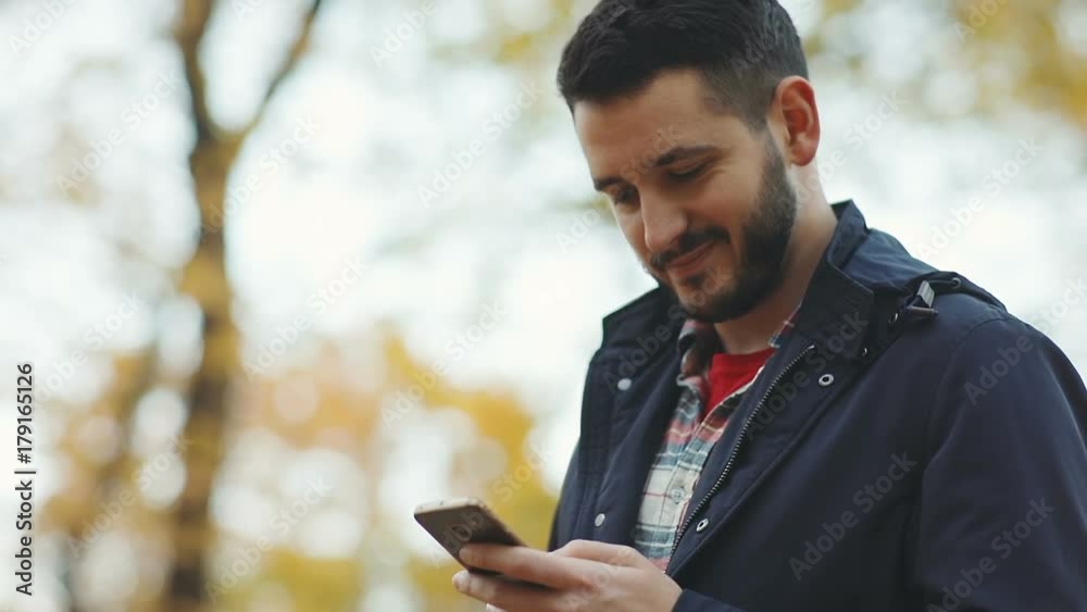 handsome confident man using holding smart phone mobile nodding head agreement agree glad satisfied guy chatting conversation online social networking checking good news outside autumn park blur trees handsome confident man using holding smart phone mobile nodding head agreement agree glad satisfied guy chatting conversation online social networking checking good news outside autumn park blur trees
