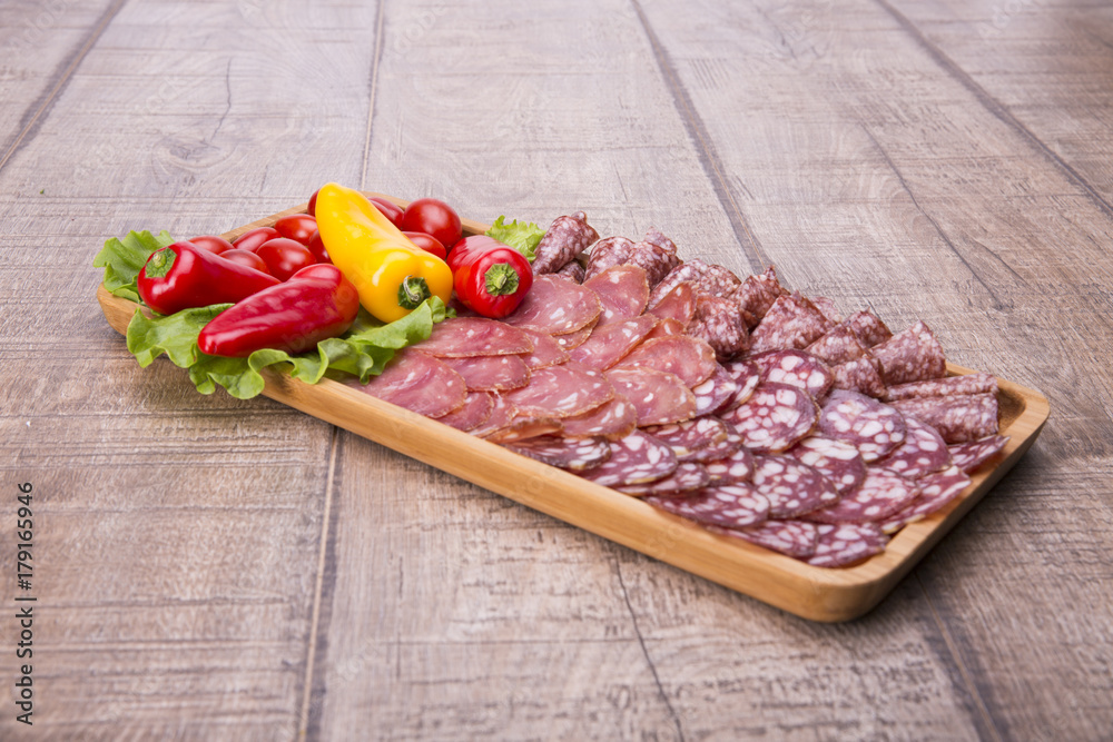 Set of meat delicatessen, tomatoes and peppers on a wooden table. Set of meat delicatessen, tomatoes and peppers on a wooden table.