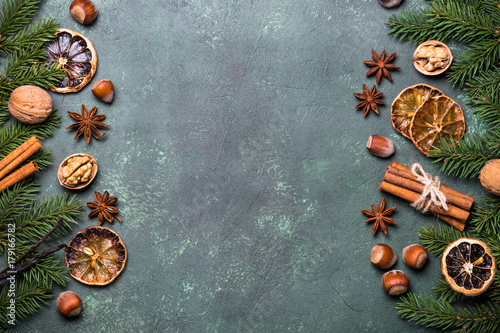 Christmas spices and decorations on green stone table. Top view copy space.