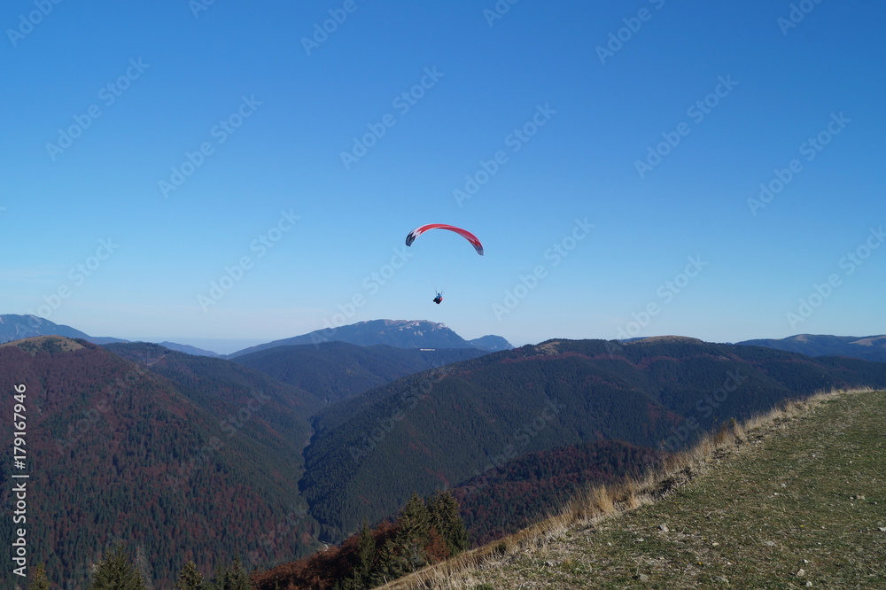 Paraglider flying over the mountains Baiului Paraglider flying over the mountains Baiului