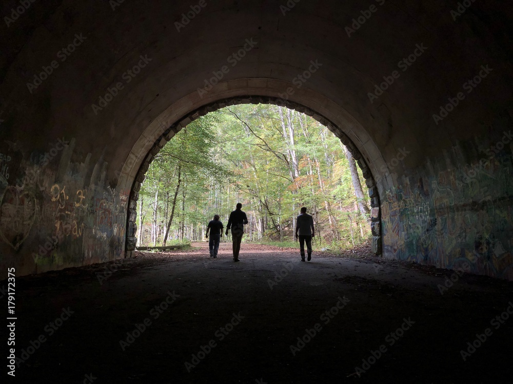three figures in a tunnel