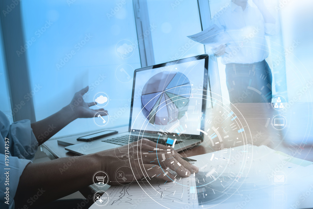 Hands of businessman using mobile phone in modern office with laptop and digital tablet computer in team meeting with VR icon diagram Hands of businessman using mobile phone in modern office with laptop and digital tablet computer in team meeting with VR icon diagram