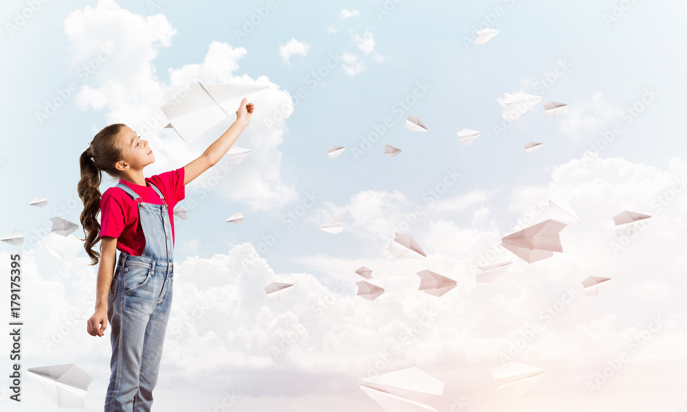 Concept of careless happy childhood with girl throwing paper plane Concept of careless happy childhood with girl throwing paper plane