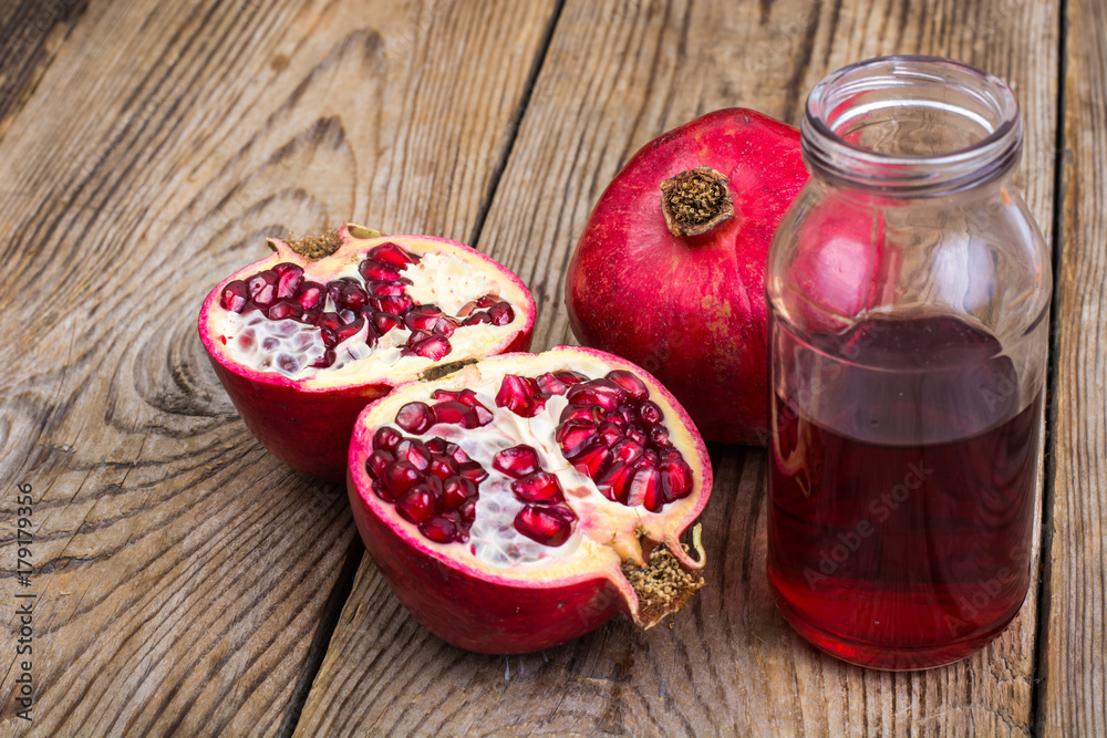 Whole and half-cut pomegranate on wooden table Whole and half-cut pomegranate on wooden table