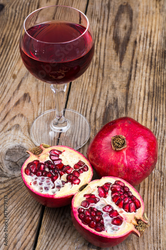 Whole and half-cut pomegranate on wooden table