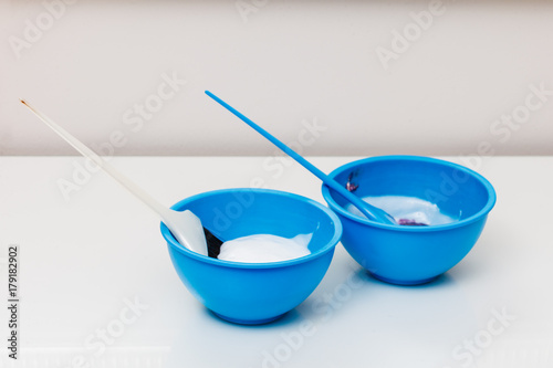 Two plastic bowls with bleach hair dye