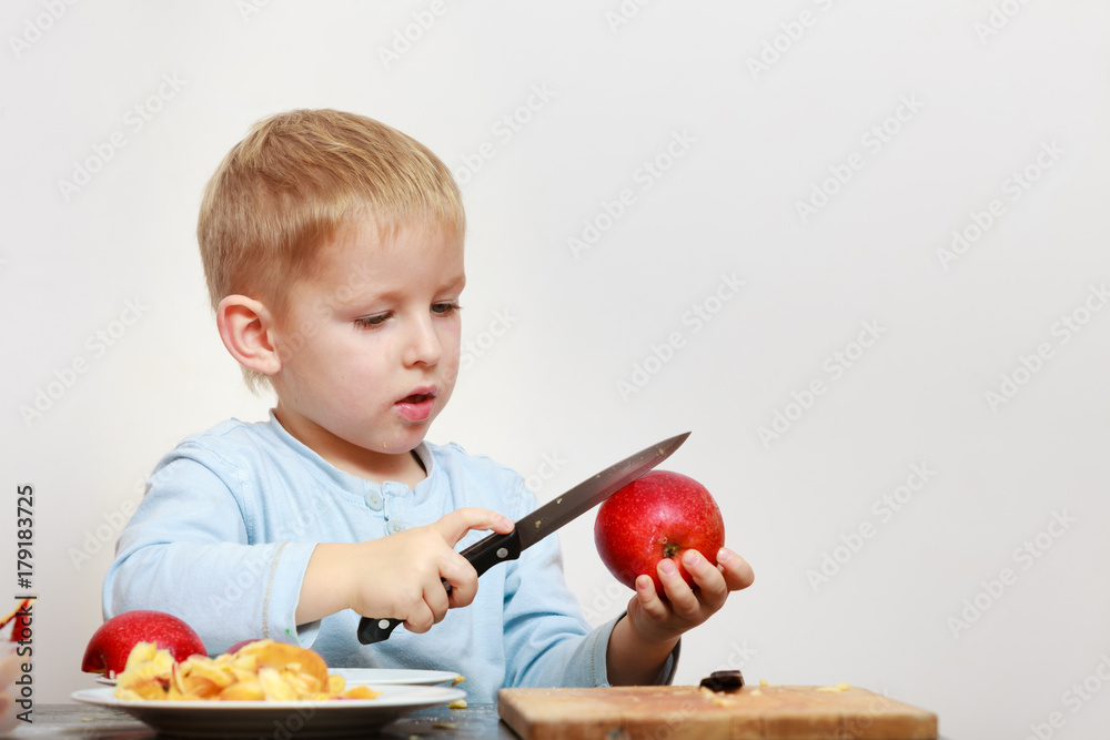 Little boy peeling apples with knife and eating Stock Photo | Adobe Stock