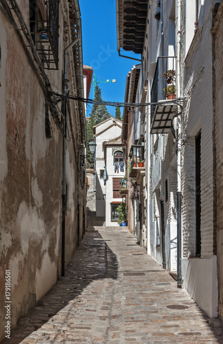 Old narrow street perspective at Albayzin district in Granada city  Spain