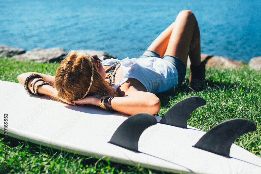 Blonde woman resting on her surfboard Blonde woman resting on her surfboard