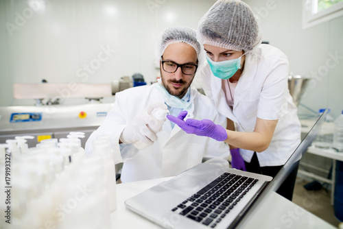 Two serious scientists checking the functionality of the product in the laboratory.