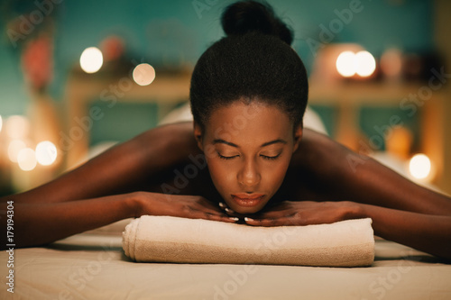 Woman relaxing on massage table at spa photo