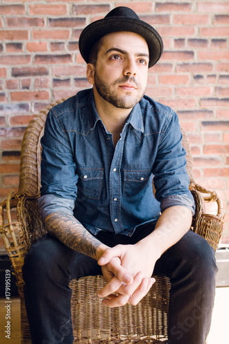 young brazillian man wearing fedora gazing outwards photo