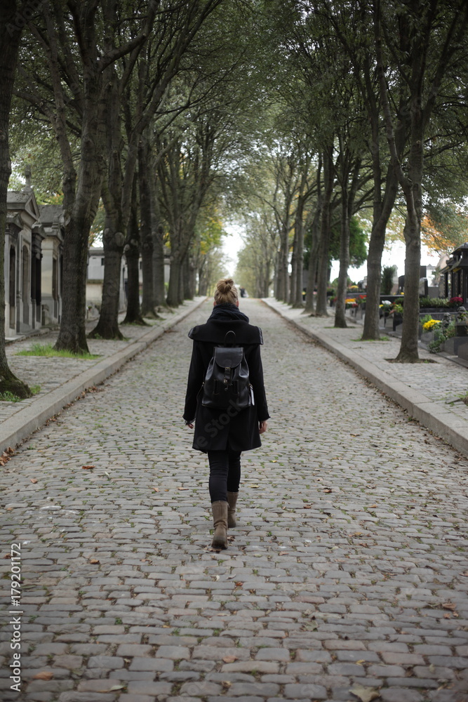 Young woman walking on historic graveyard Young woman walking on historic graveyard