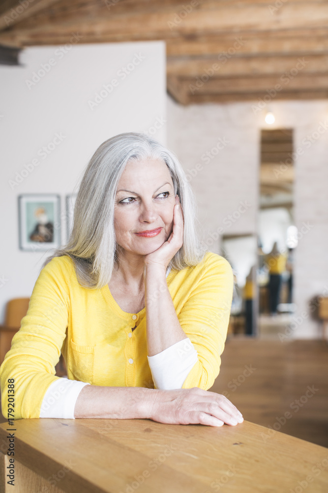 Senior woman at a counter in her living room, smiling. Senior woman at a counter in her living room, smiling.