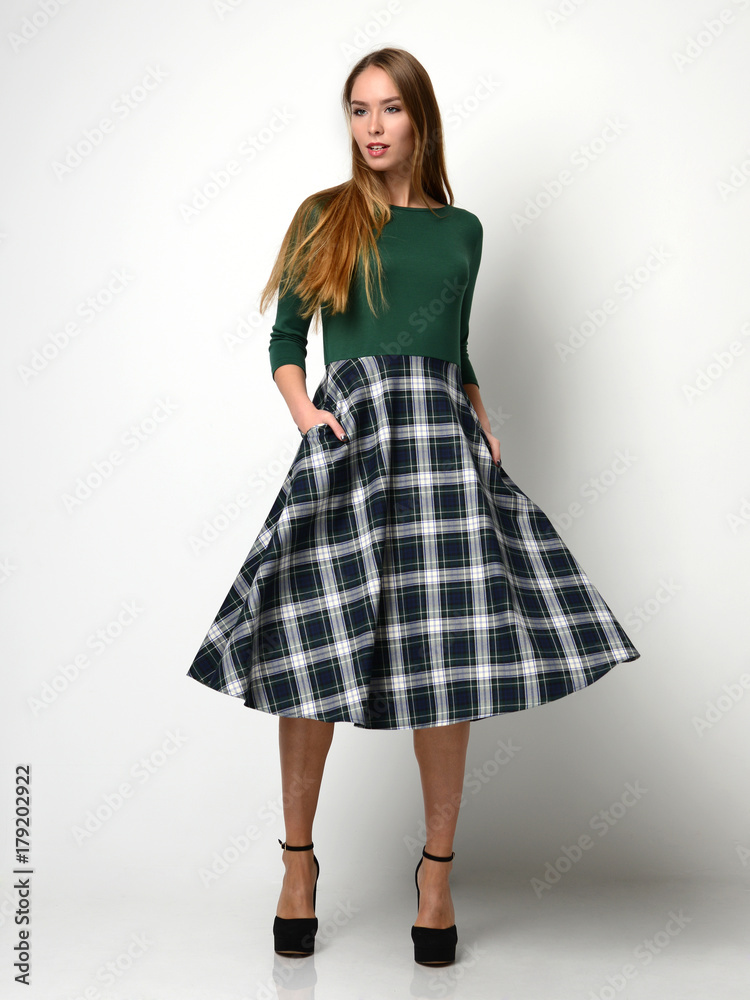 Young beautiful woman posing in new fashion plaid skirt and green blouse full body Young beautiful woman posing in new fashion plaid skirt and green blouse full body