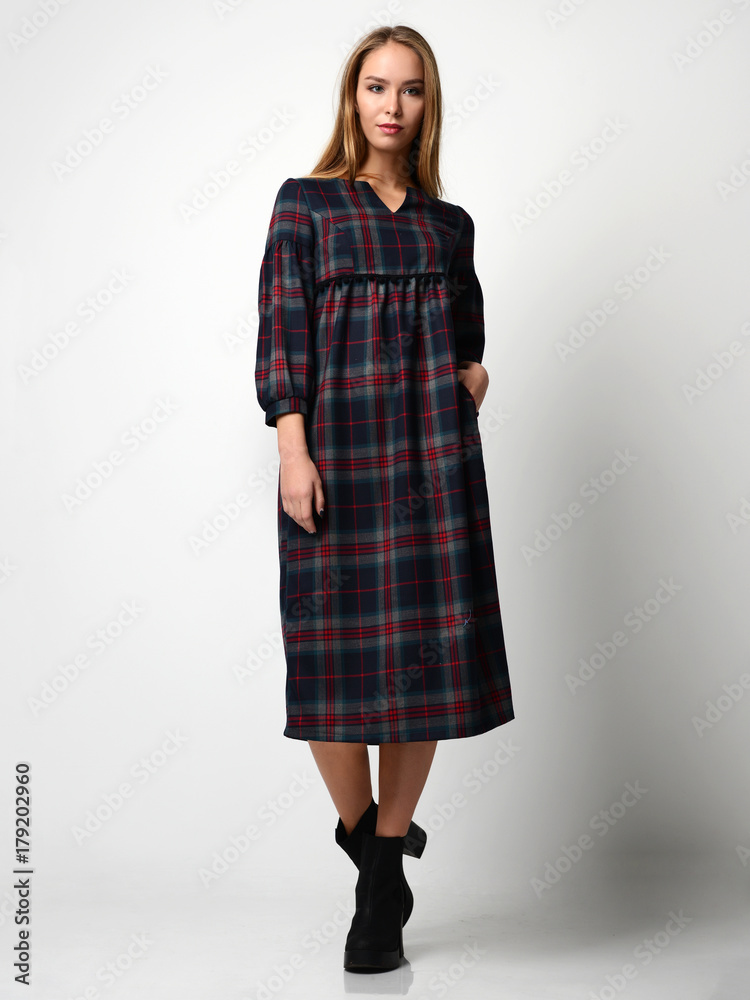 Young beautiful woman posing in new fashion gray dress in a cage full body Young beautiful woman posing in new fashion gray dress in a cage full body