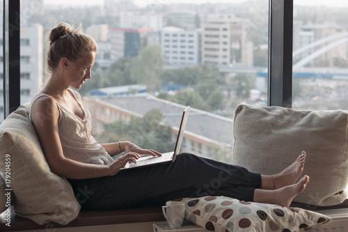 woman with laptop by the window photo