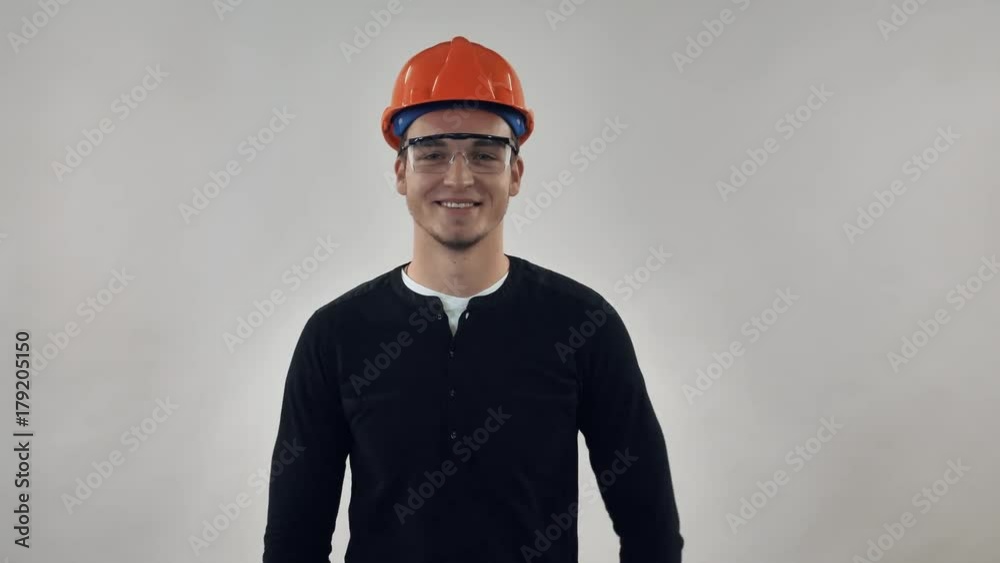 Portrait happy worker put on hard hat. Happy man wearing uniform builder or architect posing with friendly smile Portrait happy worker put on hard hat. Happy man wearing uniform builder or architect posing with friendly smile