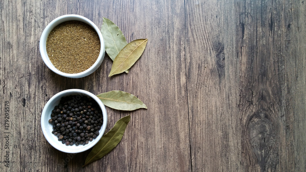 Pepper of the Kingdom powder and grain in white glass bowl on wooden background Pepper of the Kingdom powder and grain in white glass bowl on wooden background