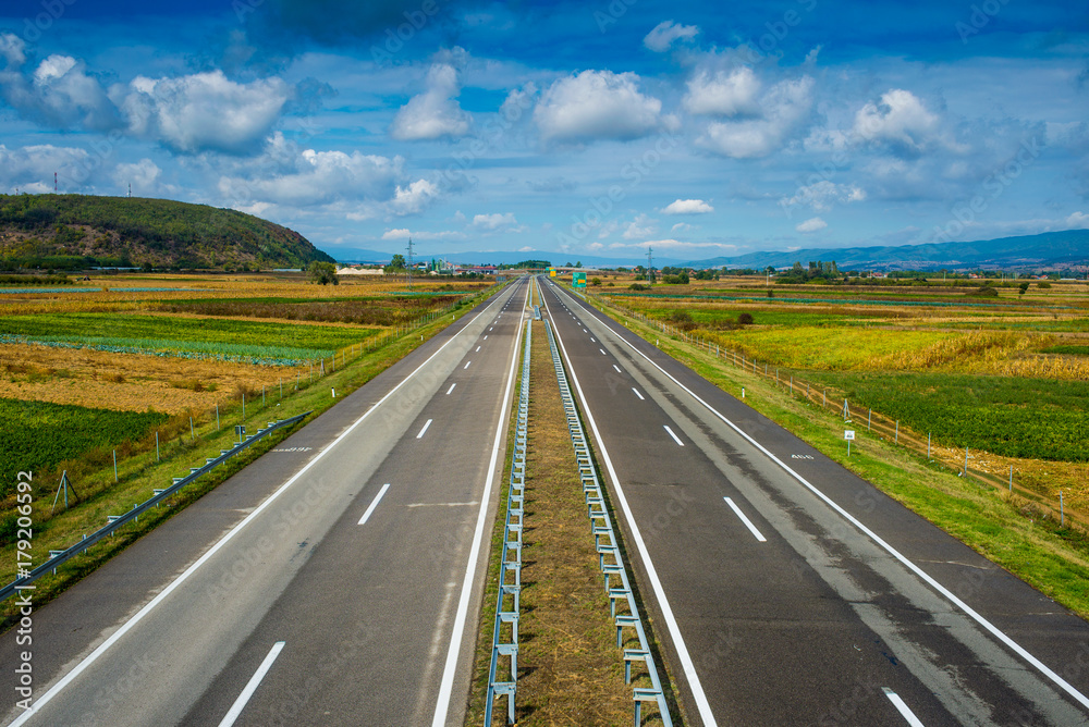 Modern empty highway going through fields