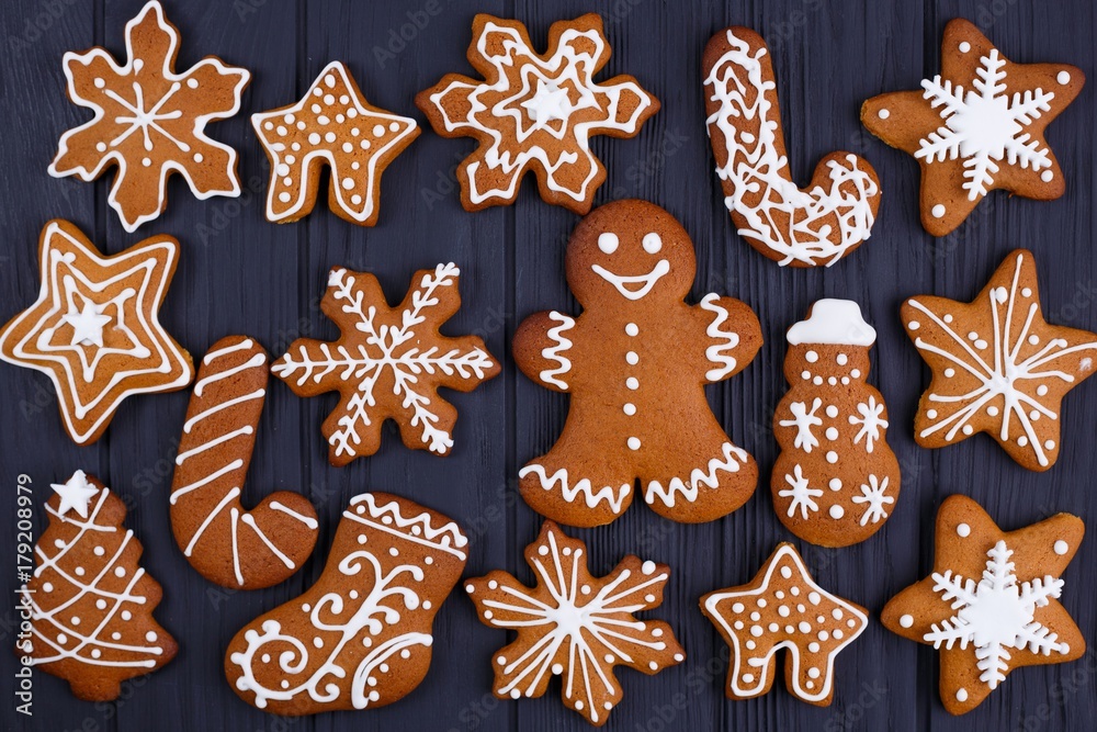Christmas background. Gingerbread cookies set on black table, flat lay. Christmas and New year traditions, winter holidays, homemade sweets, festive food