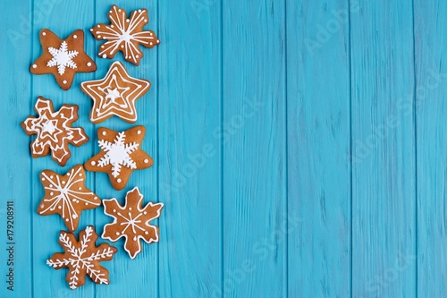 Christmas gingerbread snowflake cookies set on bright blue background, flat lay with copy space. Christmas and New year traditions, winter holidays, homemade sweets, festive food background