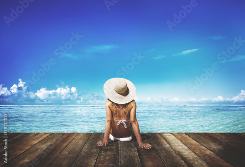 Woman tanning on a deck next to the beach