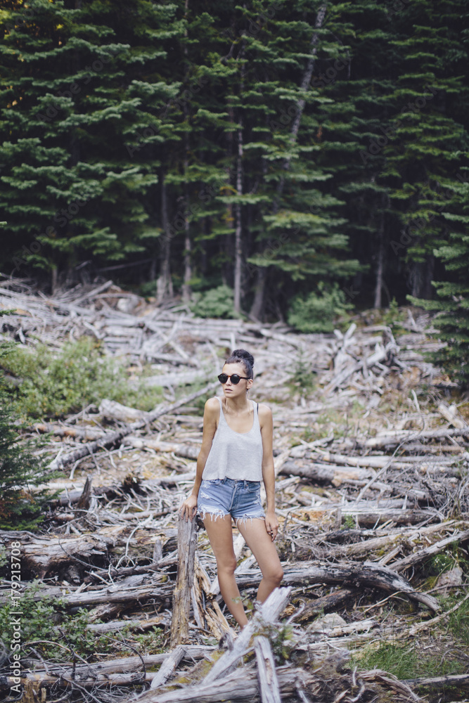 Girl standing in the trees of a fallen forest Girl standing in the trees of a fallen forest