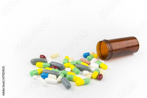 Medicine pill on white background that spilling out of pill bottle.