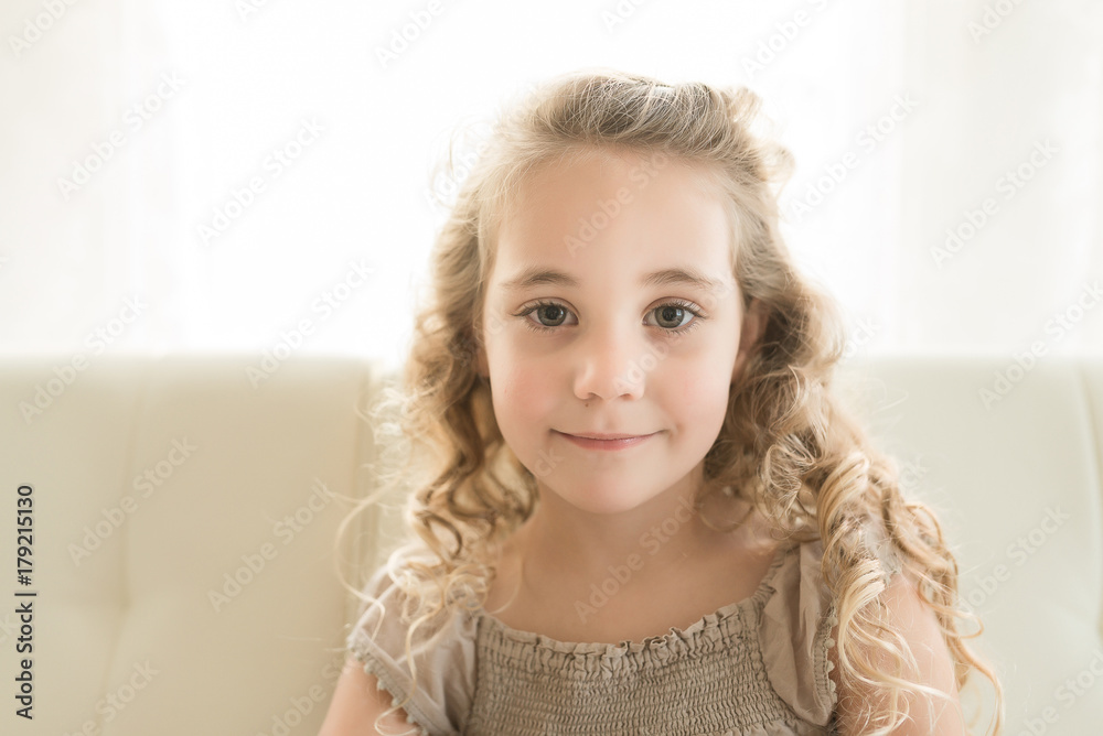 A Little Girl With Curly Hair Looks At The Camera A Little Girl With Curly Hair Looks At The Camera