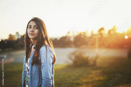 happy, thoughtful teen girl enjoying nature at sunset