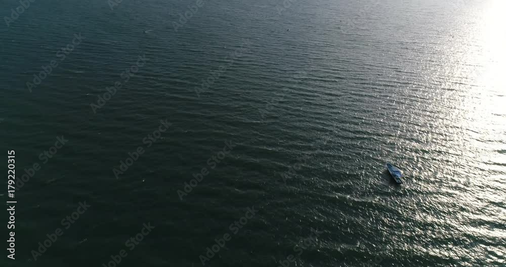 Aerial view blue boat sails on shallow turquoise ocean Aerial view blue boat sails on shallow turquoise ocean