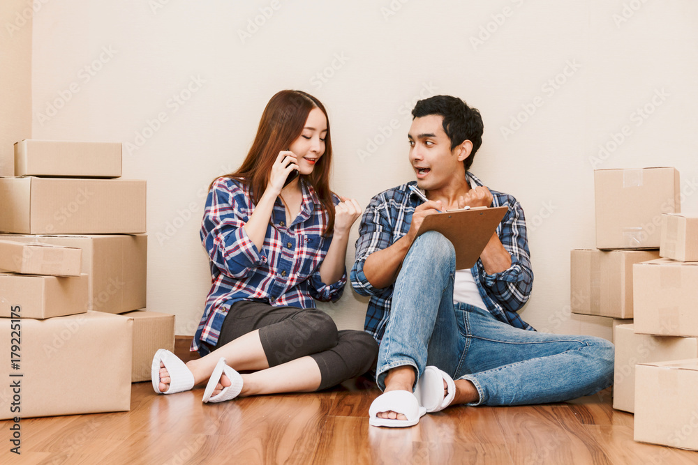 Young couple checklist with cardboard box at home - Business online and delivery concept