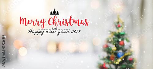 Christmas and Happy new year 2018 on blurred bokeh christmas tree with snowfall background. photo