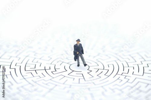 Miniature people: Businessman standing on center of maze