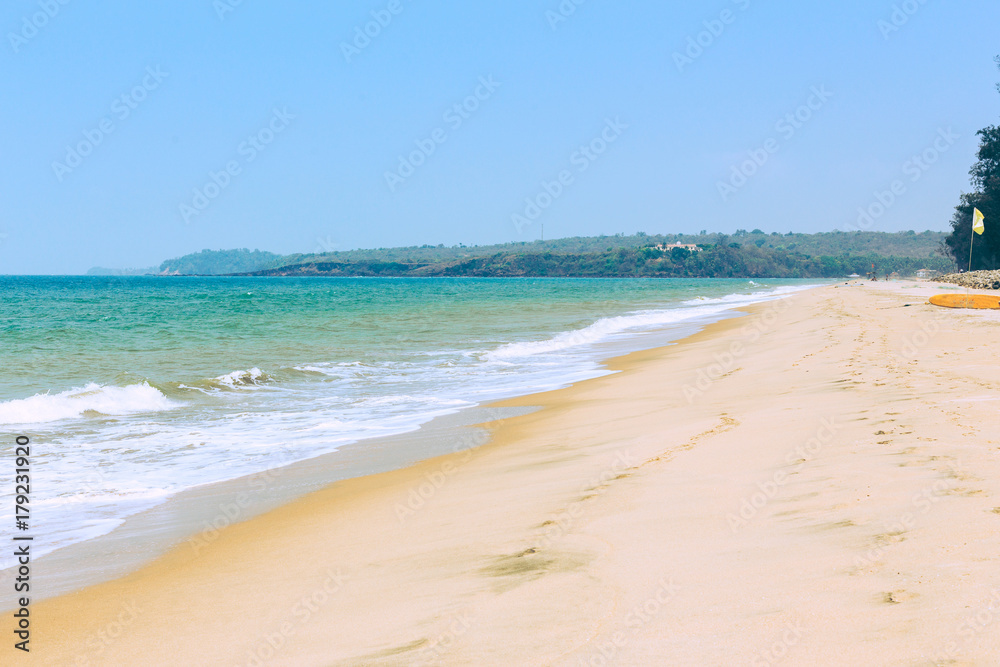 Tropical sandy beach of the sea with waves and sunny sky. Tropical sandy beach of the sea with waves and sunny sky.