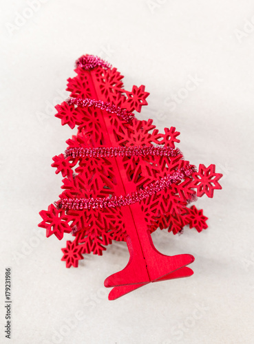 Red Christmas tree foam model decorated with little tinsel garland from the top