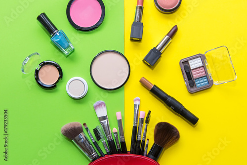 Makeup cosmetics tools background and beauty cosmetics, products and facial cosmetics package lipstick, eyeshadow on the green and yellow background. Lifestyle Concept.