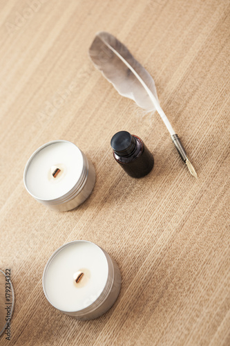 feather pen with ink, candle on the wood table. photo