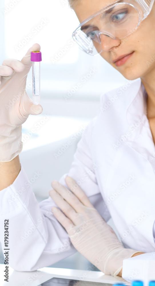 Female scientific researcher in laboratory studying substances or blood sample. Medicine and science concept Female scientific researcher in laboratory studying substances or blood sample. Medicine and science concept