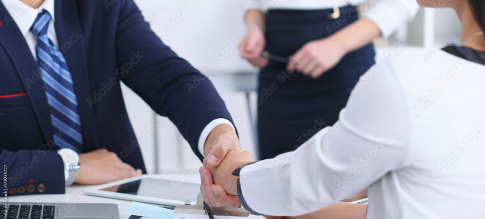 Business handshake at meeting or negotiation in the office. Partners are satisfied because signing contract or financial papers Business handshake at meeting or negotiation in the office. Partners are satisfied because signing contract or financial papers
