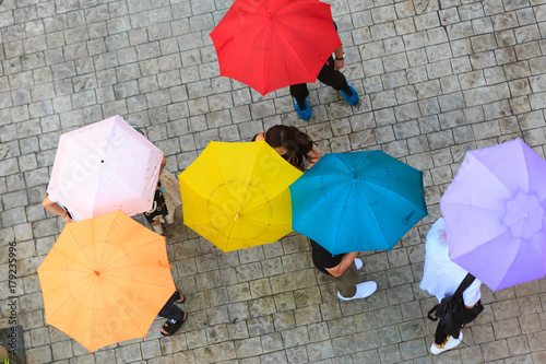 People hidden under umbrella in rainy day