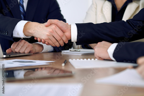 Close up of business people shaking hands at meeting or negotiation in the office. Partners are satisfied because signing contract © rogerphoto