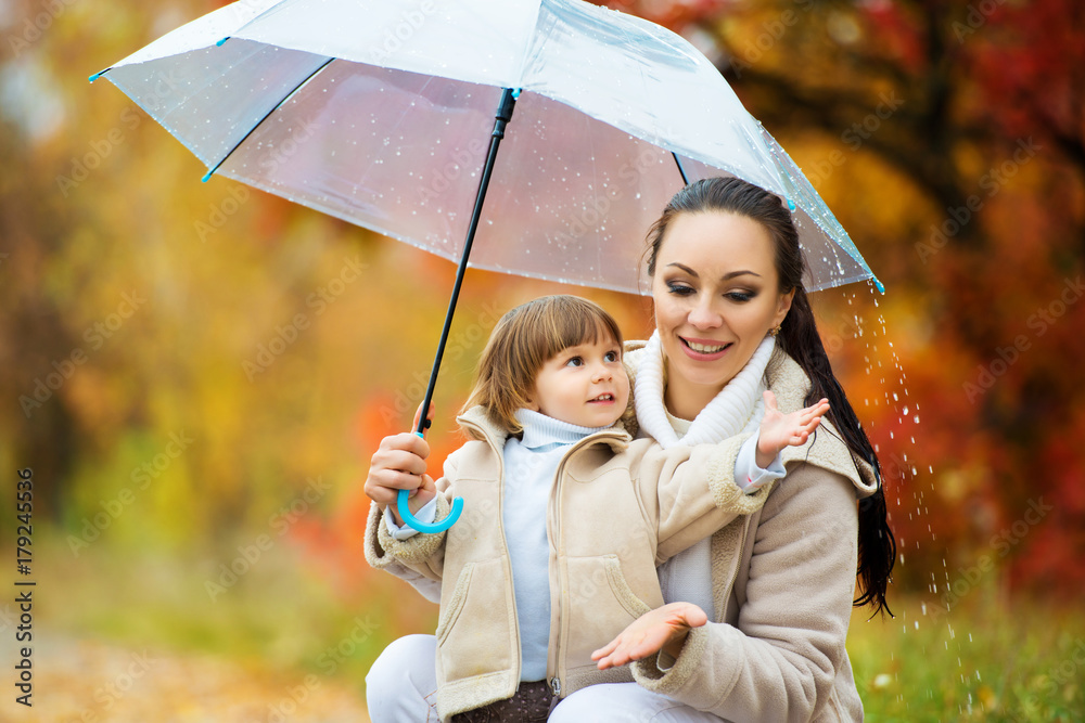Mom and daughter under the umbrella hide from the rain. Stock-Foto 
